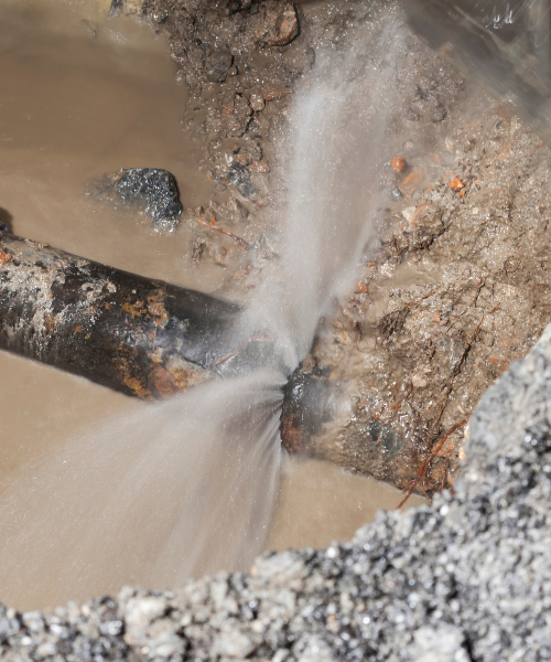 A fire hydrant spewing water out of a pipe