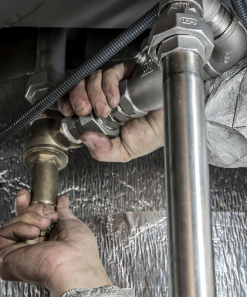 A man is working on a metal pipe